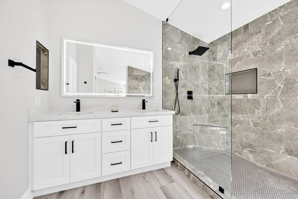 Bright white bathroom with a glass walk-in shower and grey marble tile